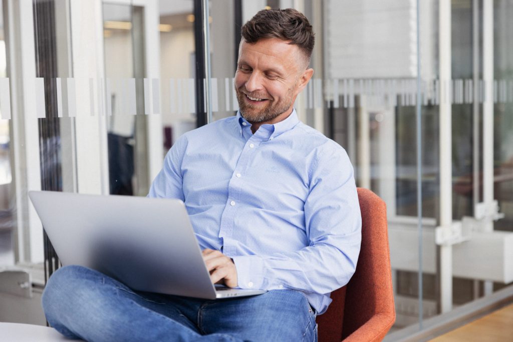 A man sits in front of a computer and thinks about loan offers